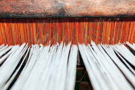 Woven threads background . Tapestry Loom with wooden base . Ancient Loom with white threadsの写真素材