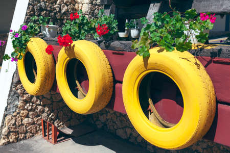 Tires and decorative flowers , street design . Rustic yard with creative decorの写真素材