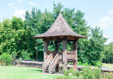 Wooden steeple with church bell . Belfry in the church yard