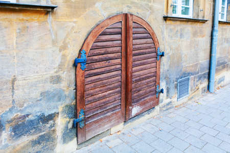 Wooden gate with arch . Pavement and house of old townの写真素材