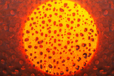 Sun circle glowing on the frozen glass . Abstract light on the frost surface . Drops backgroundの写真素材