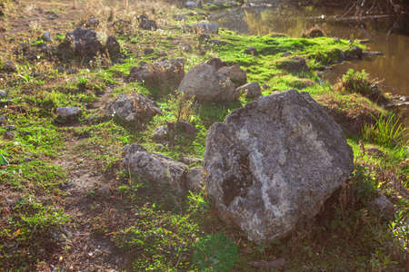 Big rocks at river bank . Idyllic riverside scenery