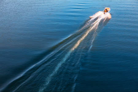 Boat trail at water surface . Moving motorboatの写真素材