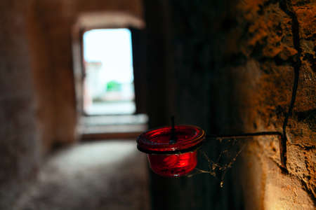 Candle lamp in the cellar . Old brick wall in dim light