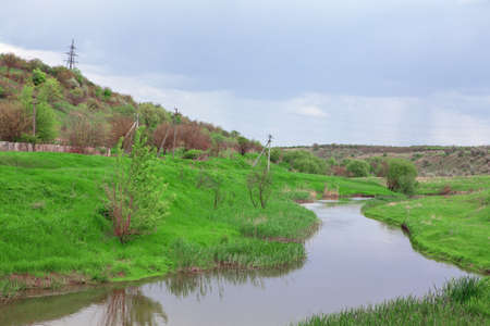 Springtime green riverside . Small river in the spring seasonの写真素材