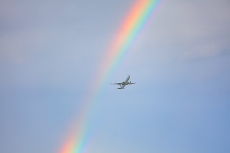 Flying plane and rainbow on the sky