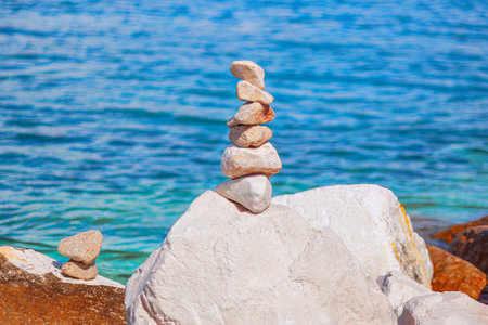 Stone pyramid on the background of the sea. The concept of harmony and balanceの写真素材