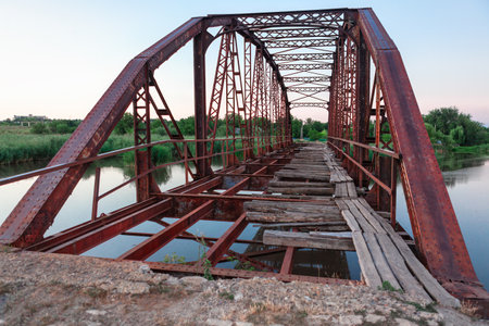 Old rusty iron bridge over the river at sunset. Russia, Tula regionの写真素材