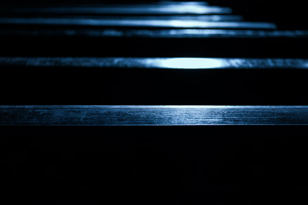 Wooden benches with sun reflection in the dark hall of the churchの写真素材