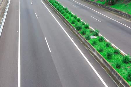 Asphalt road with green grass in the city park,Thailand