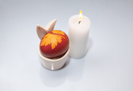 Easter egg with leaf and candle on white background. Happy Easter concept.の写真素材