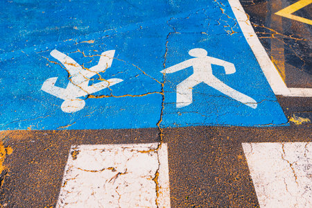 Crosswalk painted in blue and white, providing a safe path for pedestrians to cross the road....