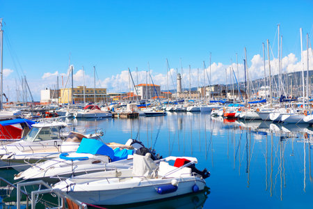 Boats docked in a marina of Trieste from Italy. Calm waters reflecting the clear blue sky aboveの写真素材