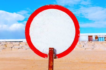 Prohibiting sign on the beach. Vibrant red and white sign, capturing attention with its contrasting colors. Sign indicating dangerous zone on a beachの写真素材