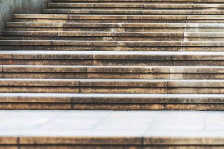 Concrete steps lead upwards, uniform in size and part of an outdoor staircase in an urban area. Weathered surface shows frequent use and exposure to the elements over timeの写真素材