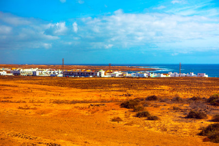 Coastal area in Lanzarote characterized by a stark contrast between the arid landscape in the...