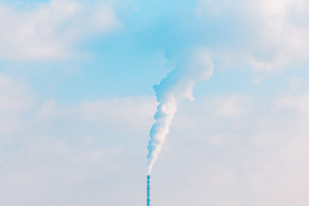 Factory chimney releasing smoke into the atmosphere. Smoke billowing from a industrial pipe, illustrating the effects of industrial processes on air qualityの写真素材