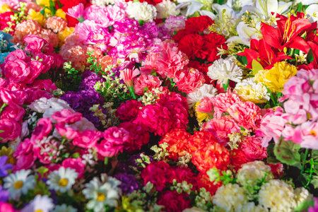 Collection of colorful natural flowers. Flowers are densely packed together, creating a visually striking and colorful display that highlights the beauty and variety of different floral speciesの写真素材