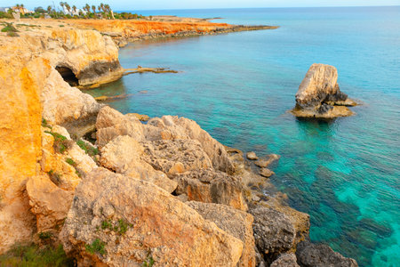Dramatic coastal cliffs meet a tranquil turquoise sea, showcasing the rugged beauty of the coastlineの写真素材