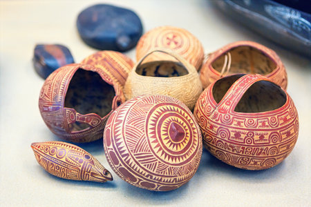 Collection of intricately carved, round and oval shaped gourds, some with handles and others cracked...
