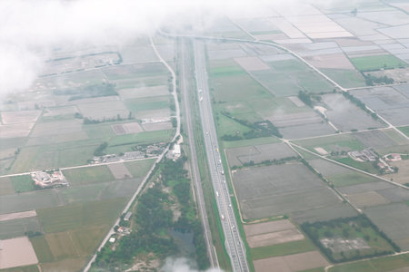 Stunning aerial view of highway cutting through a patchwork of fertile fields. Captivating blend of...