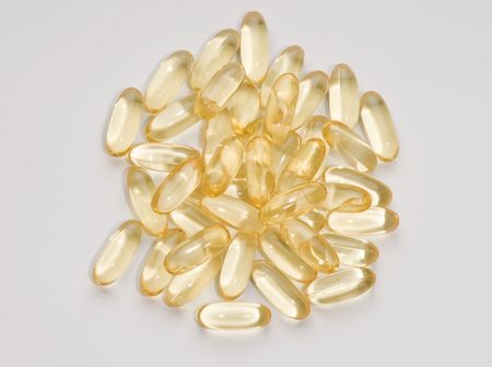 Vitamin Capsules randomly arranged on a white background
