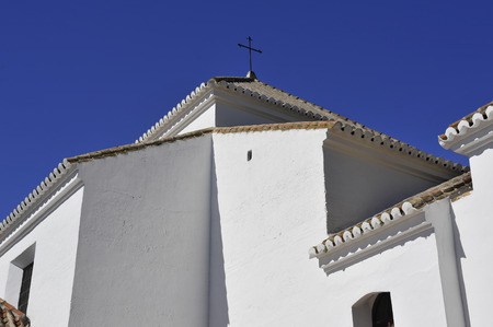 A whitewashed Spanish Andalucian church with pantiled roof and crossの写真素材