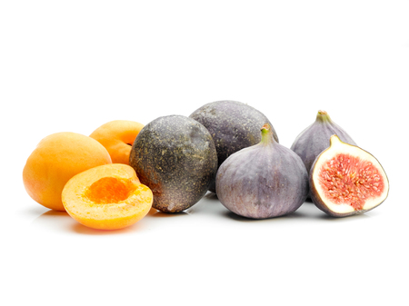 A selection of exotic fruit whole and sliced on a white background - Apricot, Passion Fruit and Figの写真素材