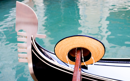 Gondoliers straw boater hat and the bow of a Gondola in Venice Italyの写真素材