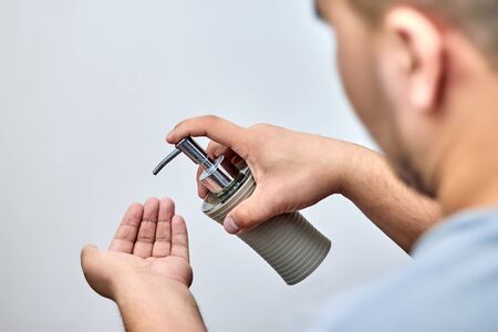 A man uses a dispenser with liquid soap. Applies to hand skin for prophylaxis against viral...