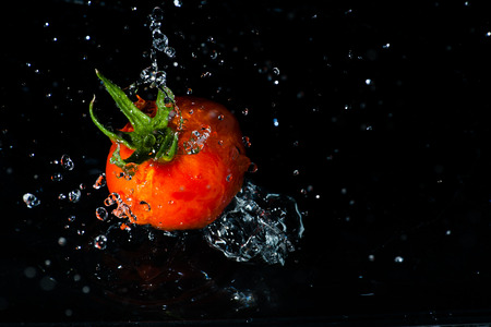 Red Tomato Splashing Into Waterの写真素材