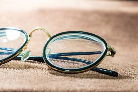 Blurred close-up a glasses on brown garment. selective focus and with a very shallow depth field.