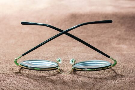 Close-up a glasses on brown garment. selective focus and with a very shallow depth field.の写真素材