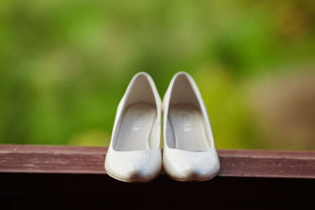 Beautiful white wedding shoes bride on the tableの写真素材