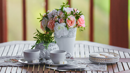 Cups for tea and a bouquet of flowers on a wooden table