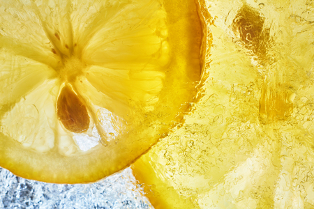 Lemon on the ice. Refreshing summer background of citrus. Yellow lemons and ice photo from above.の写真素材