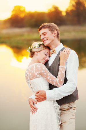 Portraits of a newly married couple. The wedding couple is standing on the background of the order. Lovers are happy.の写真素材