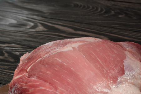 Raw pork shoulder close-up. Pork tenderloin on paper on a dark tableの写真素材