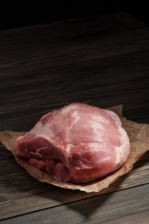 Raw pork shoulder. Pork tenderloin on paper on a dark tableの写真素材