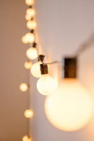 Garland with lamps on a white wall in the apartmentの写真素材