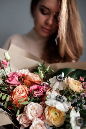 Satisfied beautiful woman with bouquet of flowersの写真素材