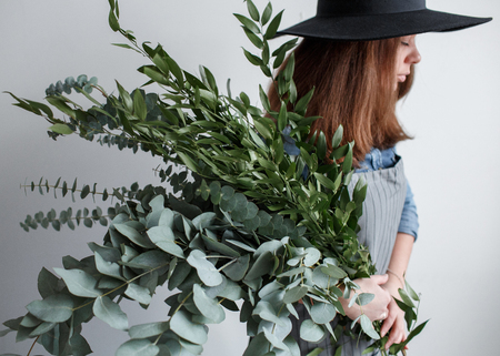 florist in apron makes a bouquet of eucalyptus leavesの写真素材
