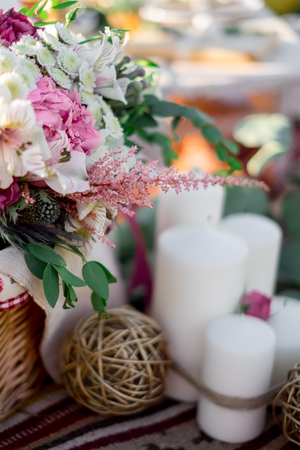 A delicate bouquet of flowers in a basket. Wedding decoration in natureの写真素材