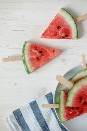 fresh slices of ripe watermelon at white  wooden background.の写真素材
