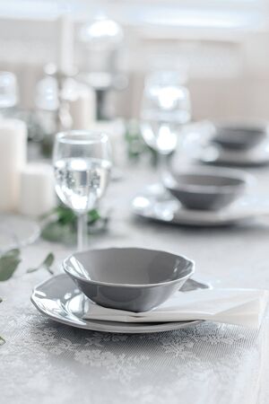 Wedding or festive table setting. Plates, wine glasses, candles and cutlery . Beautiful arrangement.の写真素材