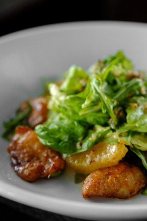 Juicy salad with chicken steak, salad mix, orange, cheese. Under the olive oil. In a round plate.の写真素材