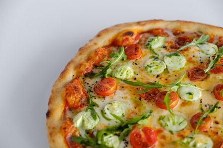 Pizza with tomatoes and arugula and mozzarella. White backgroundの写真素材
