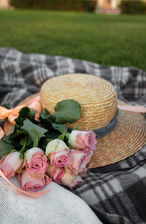 Picnic. Straw hat and pink  flowers on the lawnの写真素材