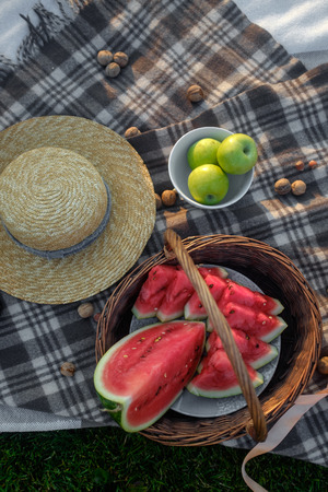 Picnic on a cozy plaid. Sliced watermelon in a basketの写真素材