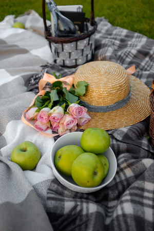 Picnic. Straw hat and pink  flowers on the lawnの写真素材